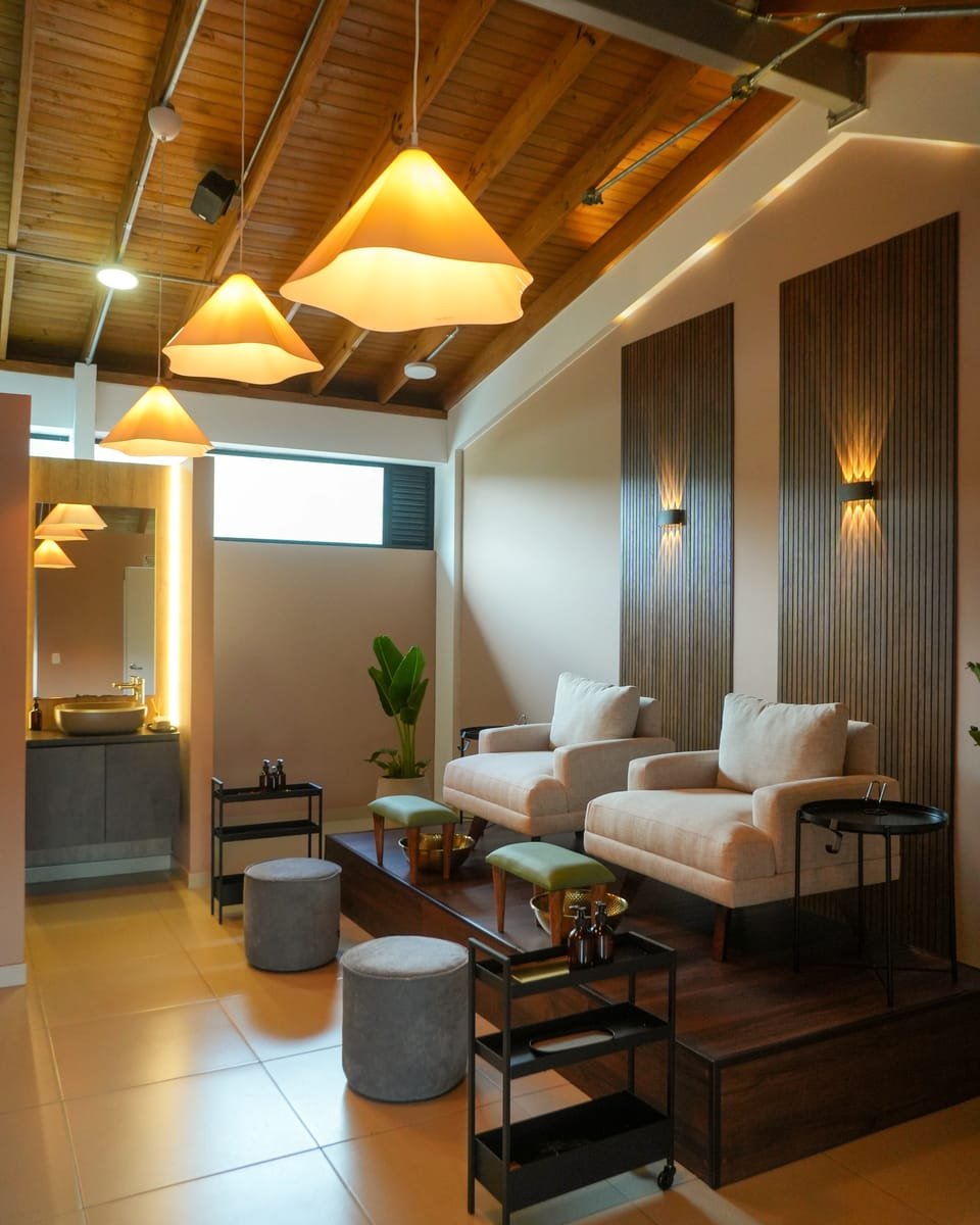 Interior del estudio Alma House: sillón crema, luz natural y pared en verde oliva